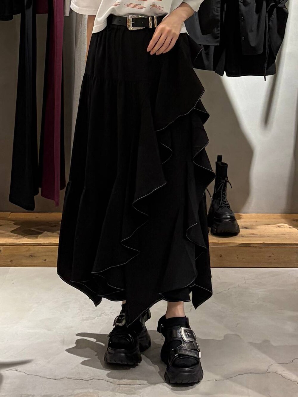 ブラック系のスカート、ブラック系のサンダル、ホワイト系のTシャツ/カットソーを着用したレディースの春コーディネートの5枚目の写真