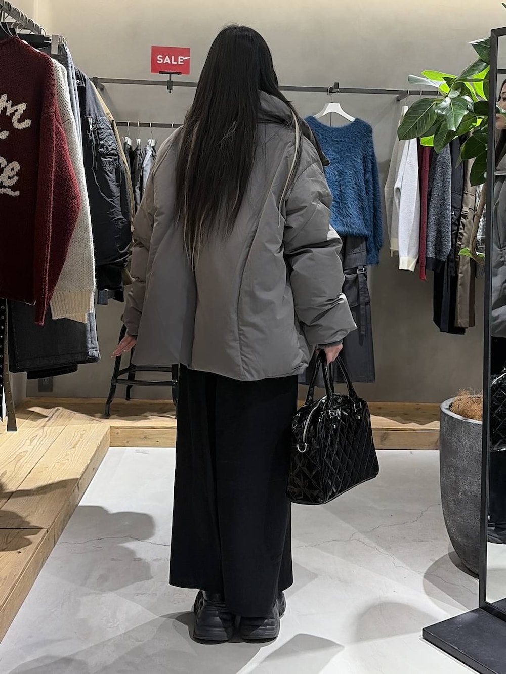 ブラック系のブーツ、グレー系のブルゾン、ブルー系のニット/セーターを着用したレディースの冬コーディネートの3枚目の写真