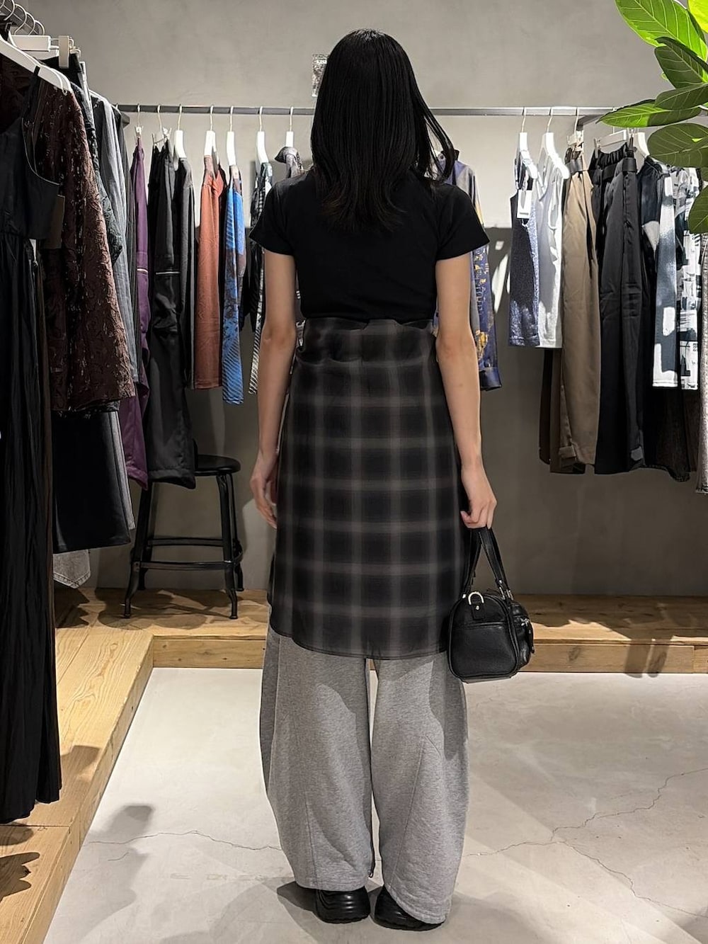 ブラック系のショルダーバッグ、ブラック系のシャツ/ブラウス、グレー系のスウェットパンツを着用したレディースの夏コーディネートの3枚目の写真