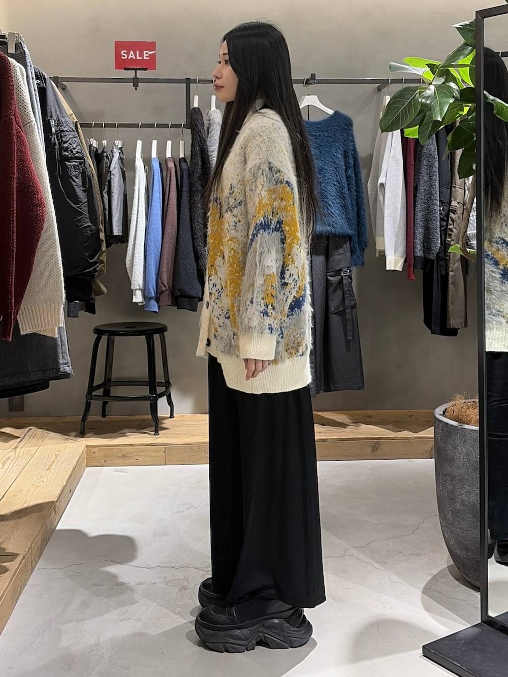 ホワイト系のカーディガン/ボレロ、ホワイト系のニット/セーター、ブラック系のスカートを着用したレディースの冬コーディネートの2枚目の写真