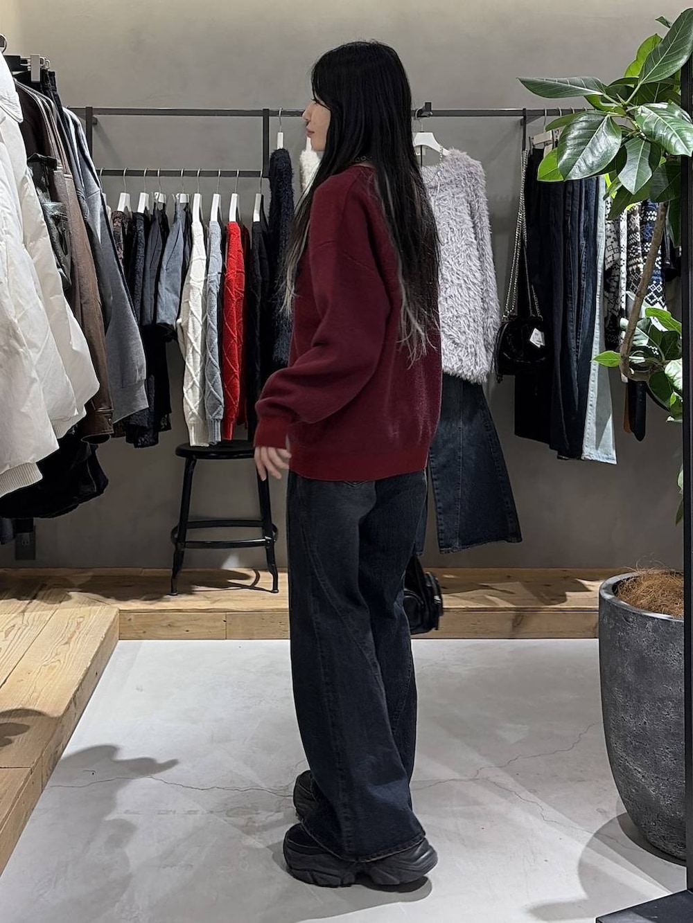 ブラック系のブーツ、ブルー系のデニムパンツ、ブラック系のショルダーバッグを着用したレディースの冬コーディネートの2枚目の写真