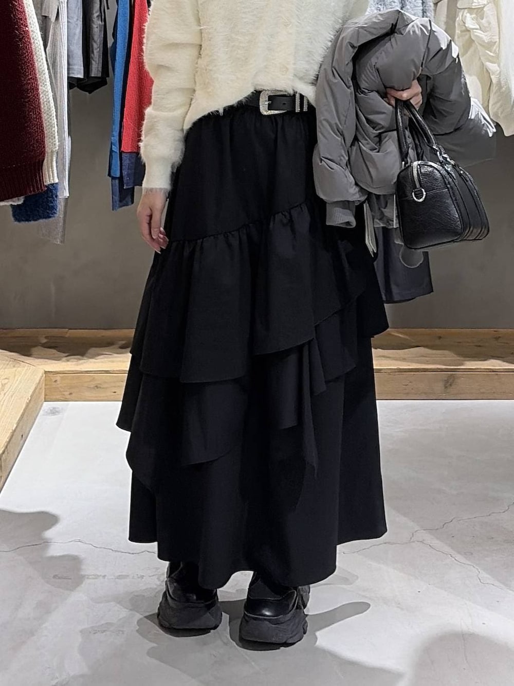 グレー系のブルゾン、ブラック系のスカート、ブラック系のボストンバッグを着用したレディースの冬コーディネートの5枚目の写真