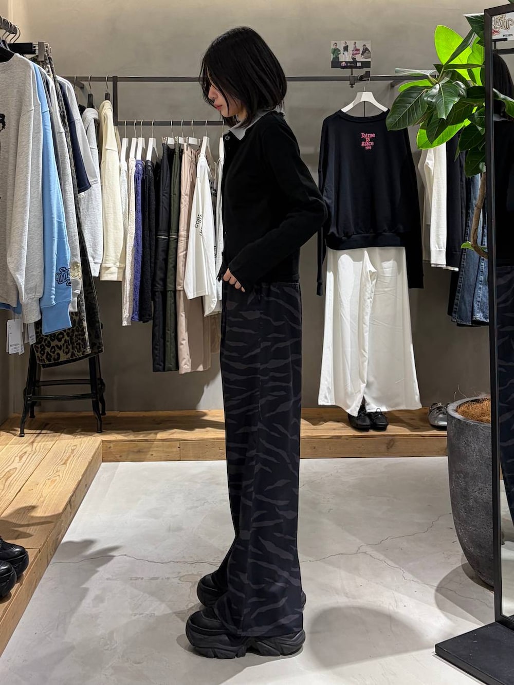 ブラック系のブーツ、その他のスラックス、グレー系のカーディガン/ボレロを着用したレディースの春コーディネートの2枚目の写真