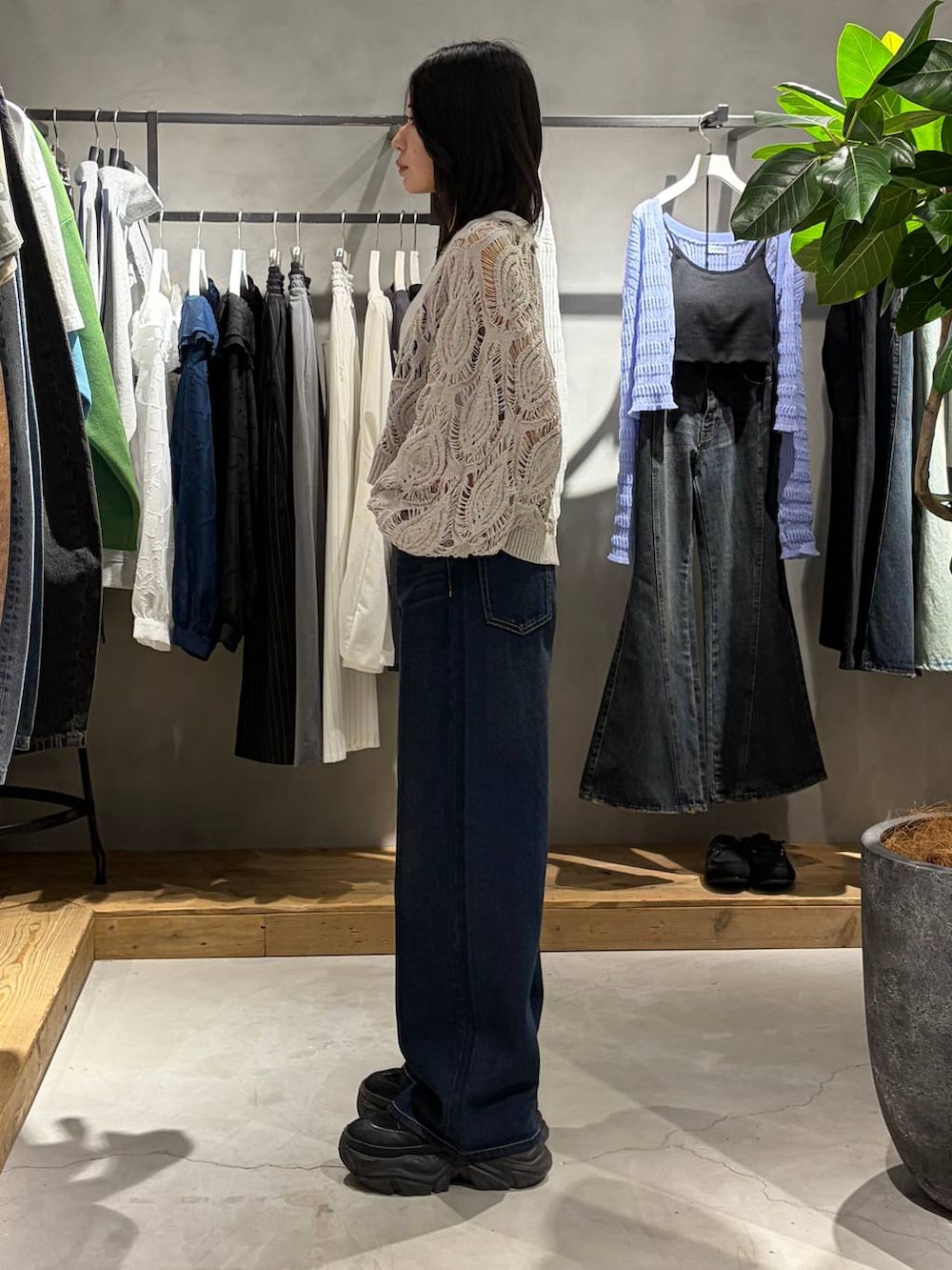 ブラック系のブーツ、ブラック系のキャミソール、ベージュ系のカーディガン/ボレロを着用したレディースの春コーディネートの2枚目の写真