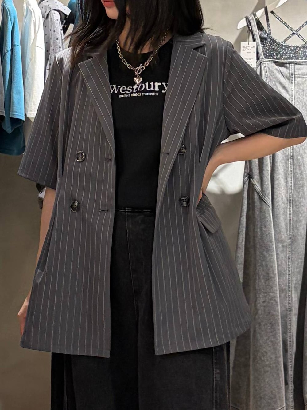 ブラック系のデニムパンツ、ブラック系のTシャツ/カットソー、ブラック系のサンダルを着用したレディースの夏コーディネートの4枚目の写真