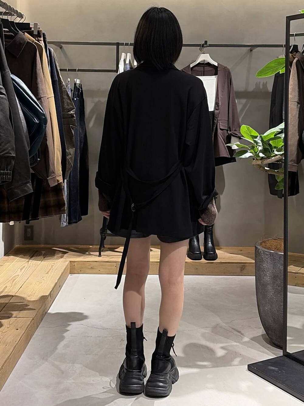 ブラック系のブーツ、ブラック系のテーラードジャケット、ブラウン系のニット/セーターを着用したレディースの秋コーディネートの3枚目の写真