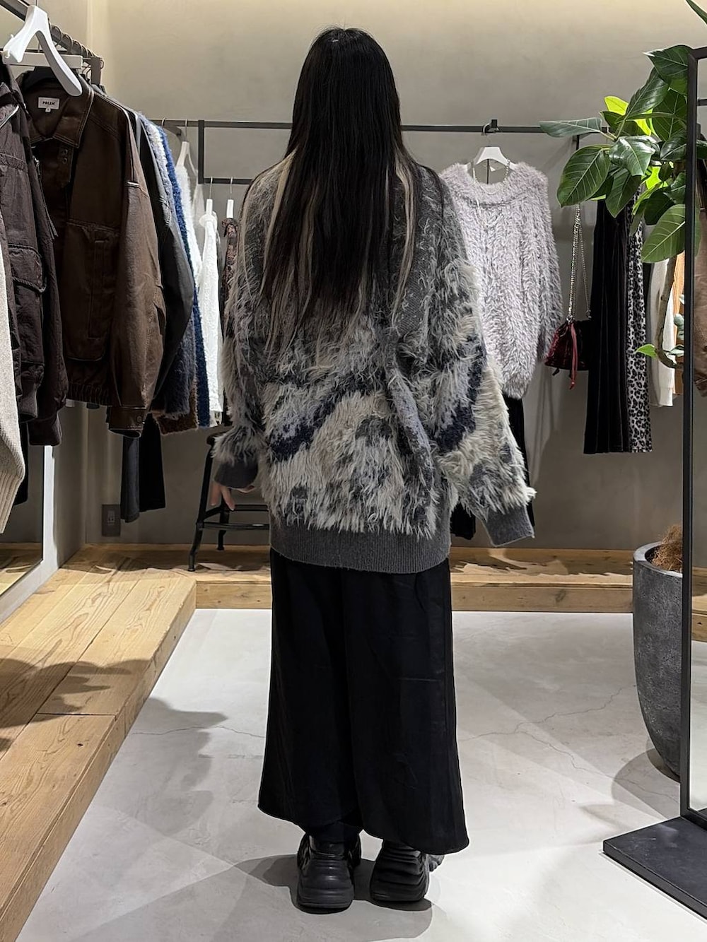 ブラック系のブーツ、グレー系のカーディガン/ボレロ、ブラック系のニット/セーターを着用したレディースの冬コーディネートの3枚目の写真