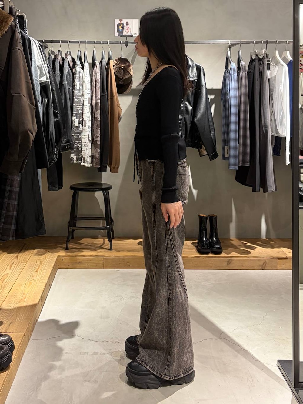 ブラック系のニット/セーター、ブラック系のデニムパンツ、シルバー系のネックレスを着用したレディースの秋コーディネートの2枚目の写真