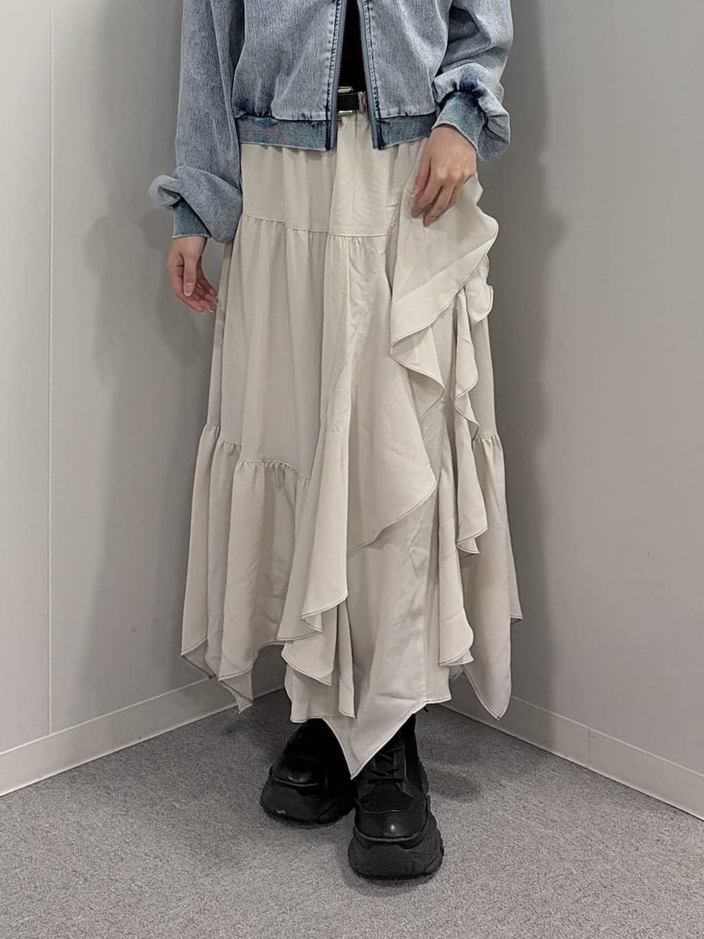 ブラック系のブーツ、ブラック系のニット/セーター、ベージュ系のスカートを着用したレディースの冬コーディネートの5枚目の写真