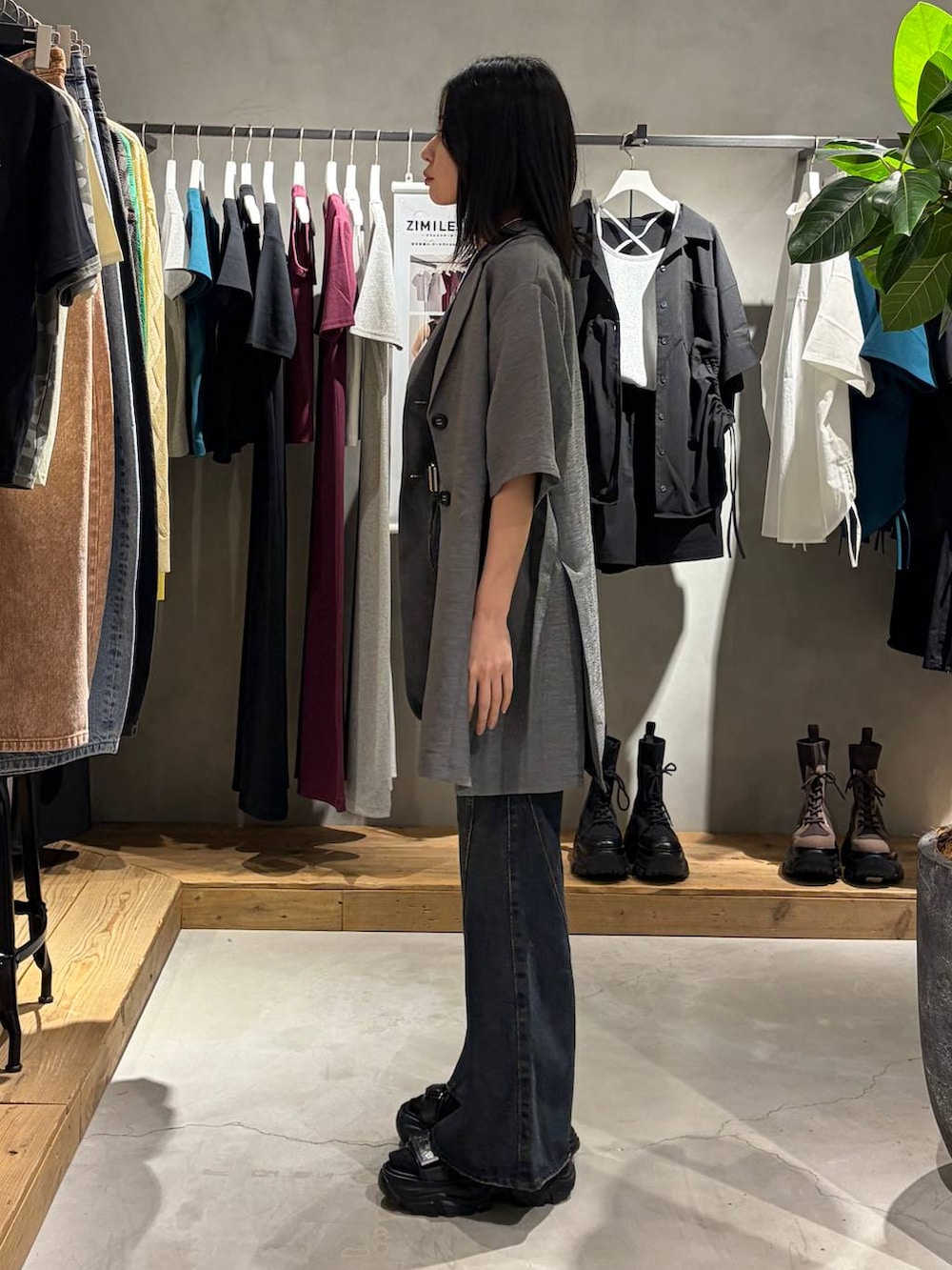 ブルー系のデニムパンツ、ブラック系のサンダル、ブラック系のTシャツ/カットソーを着用したレディースの春コーディネートの2枚目の写真