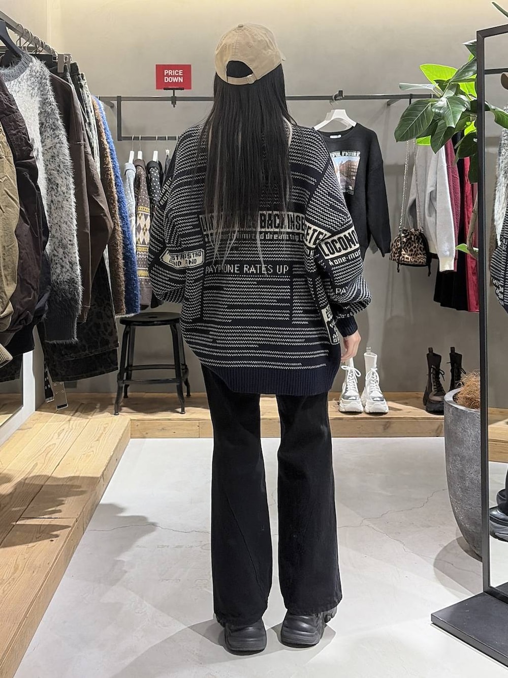 ブラック系のブーツ、ブラック系のデニムパンツ、ブルー系のニット/セーターを着用したレディースの冬コーディネートの3枚目の写真