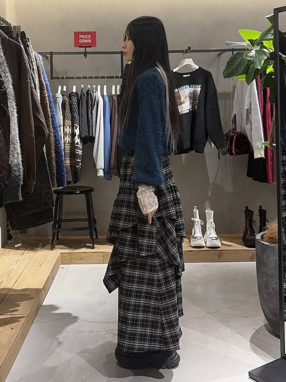 ブラック系のブーツ、ホワイト系のTシャツ/カットソー、ホワイト系のスカートを着用したレディースの冬コーディネートの2枚目の写真