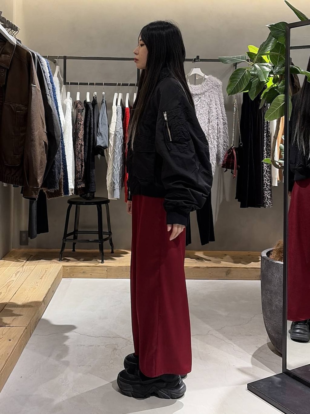 ブラック系のブーツ、ブラック系のブルゾン、レッド系のスカートを着用したレディースの冬コーディネートの2枚目の写真