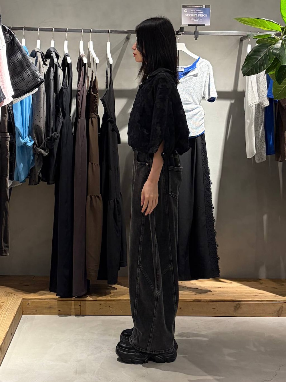 ブラック系のスニーカー、ブラック系のデニムパンツ、ブラック系のシャツ/ブラウスを着用したレディースの夏コーディネートの2枚目の写真