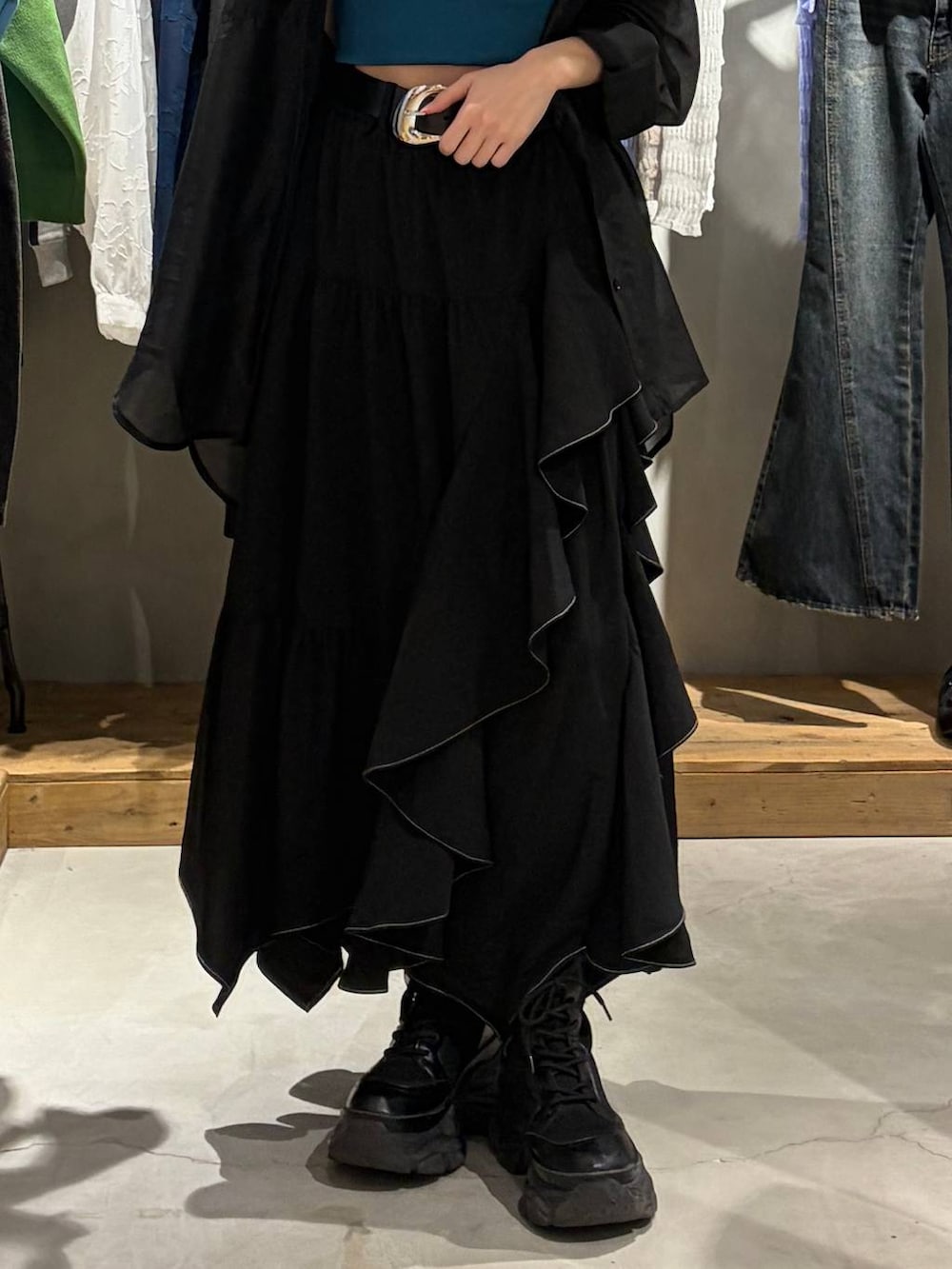 ブラック系のブーツ、グリーン系のキャミソール、ブラック系のスカートを着用したレディースの春コーディネートの5枚目の写真