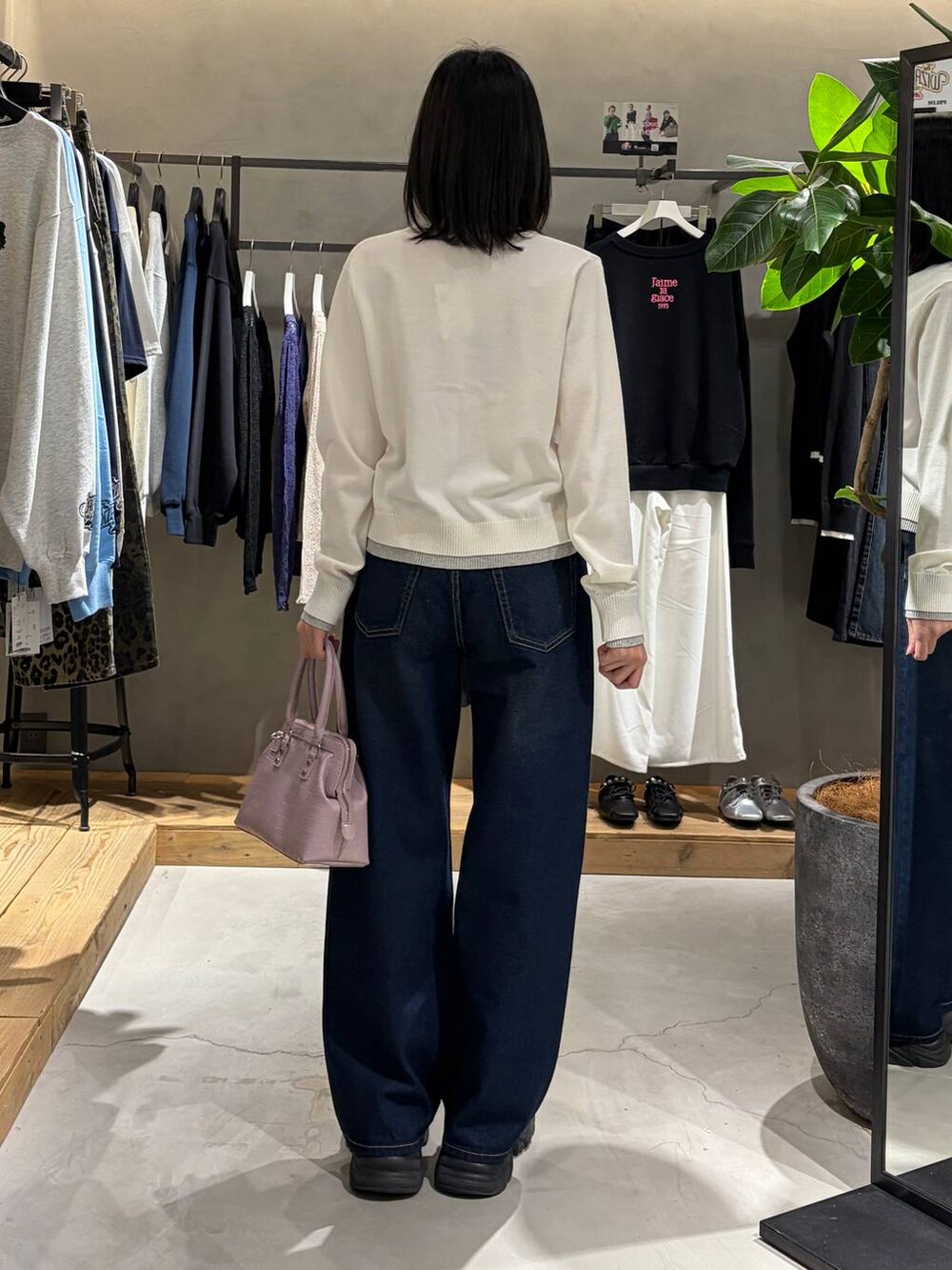 ブラック系のブーツ、ブルー系のスラックス、ピンク系のハンドバッグを着用したレディースの冬コーディネートの3枚目の写真