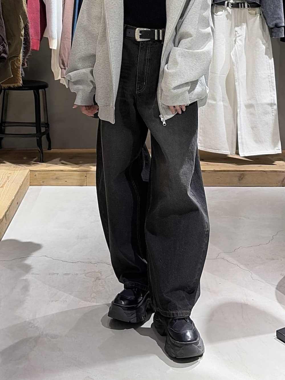 ブラック系のブーツ、グレー系のパーカー、ブラック系のデニムパンツを着用したレディースの冬コーディネートの5枚目の写真