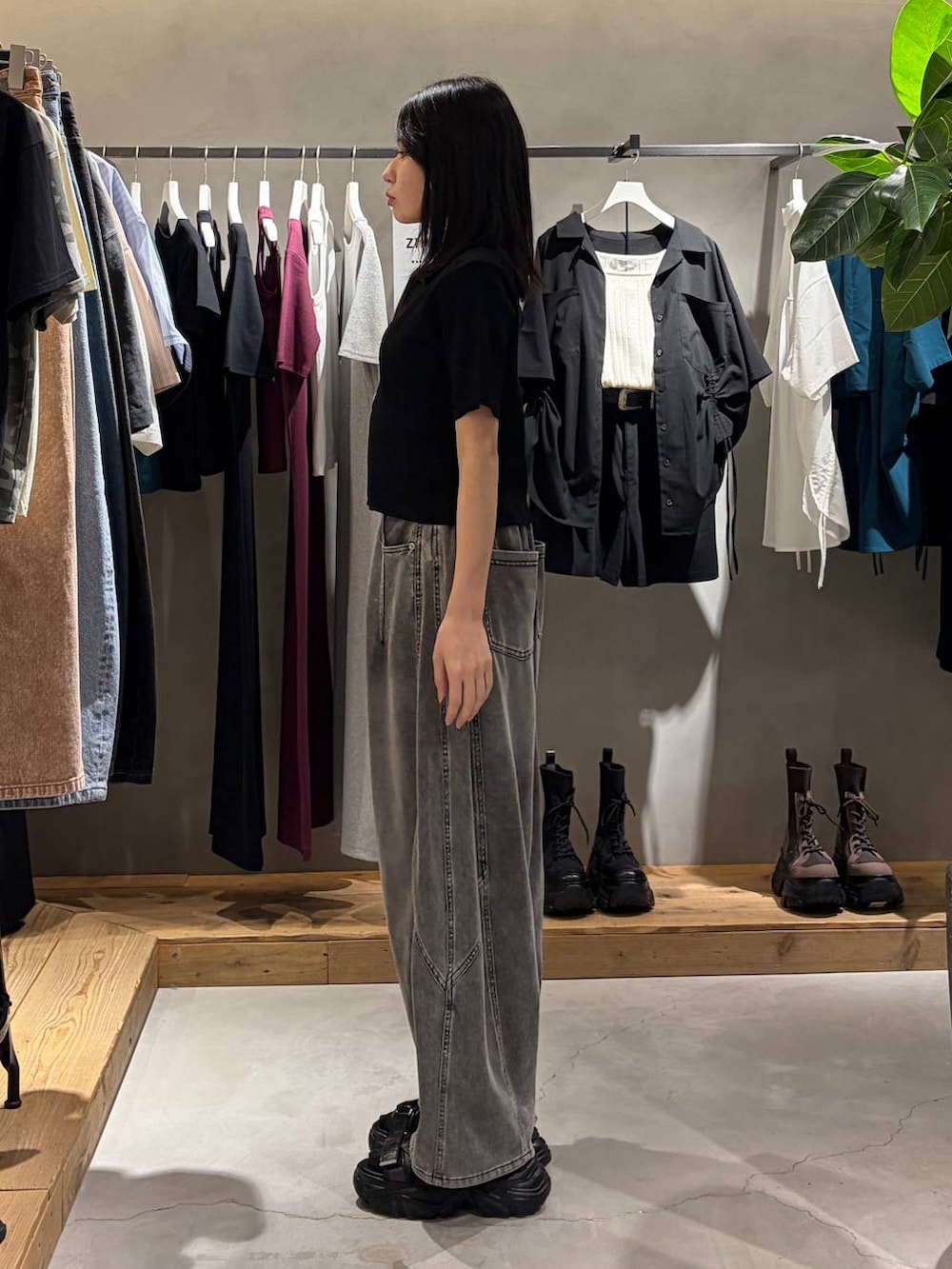 ブラック系のキャミソール、ブラック系のデニムパンツ、ブラック系のサンダルを着用したレディースの春コーディネートの2枚目の写真