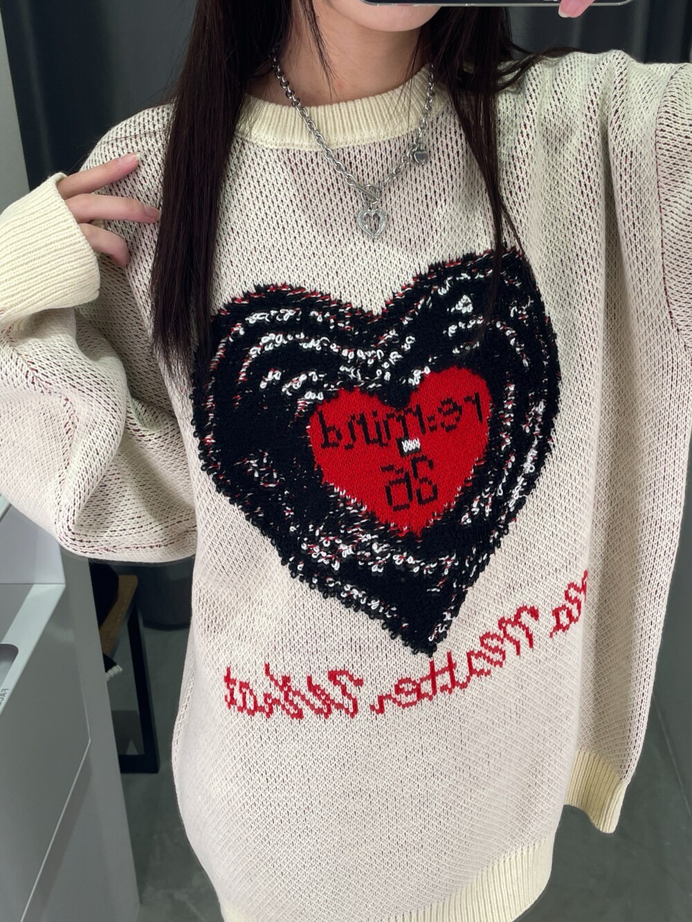 ホワイト系のニット/セーター、ブラック系のパンツ、ブラック系のブーツを着用したレディースの冬コーディネートの2枚目の写真