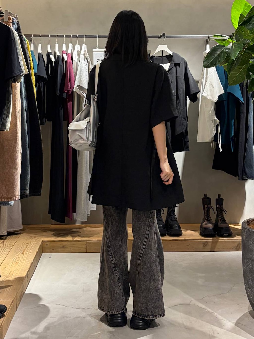 ブラック系のデニムパンツ、ブラック系のテーラードジャケット、シルバー系のハンドバッグを着用したレディースの春コーディネートの3枚目の写真