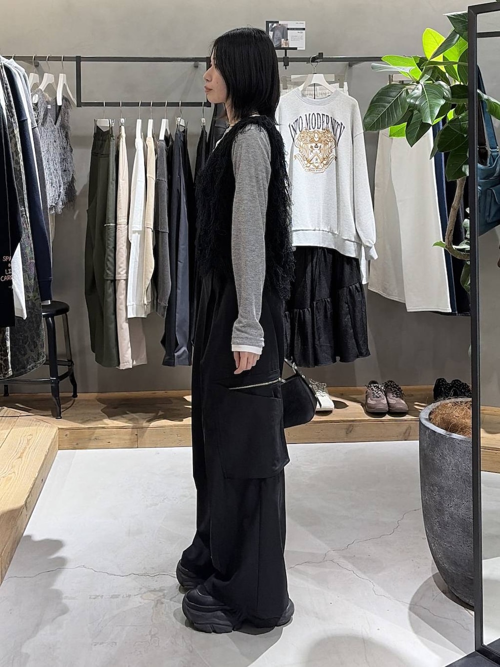 ブラック系のブーツ、ブラック系のハンドバッグ、ブラック系のスラックスを着用したレディースの冬コーディネートの2枚目の写真