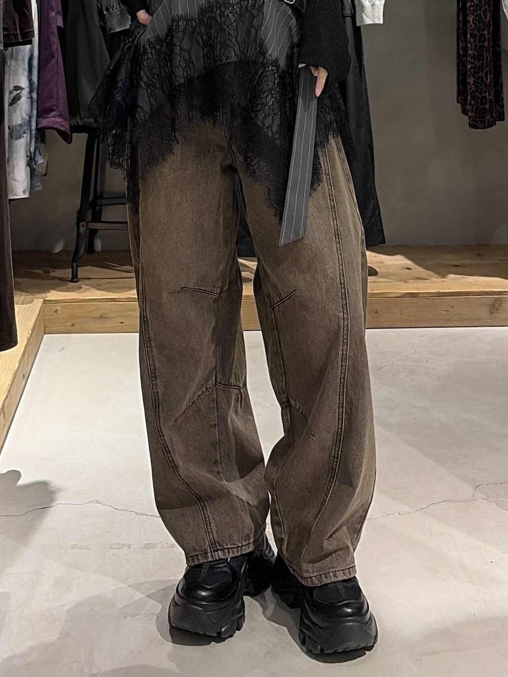 ブラウン系のデニムパンツ、ブラック系のスニーカー、ブラック系のニット/セーターを着用したレディースの夏コーディネートの5枚目の写真