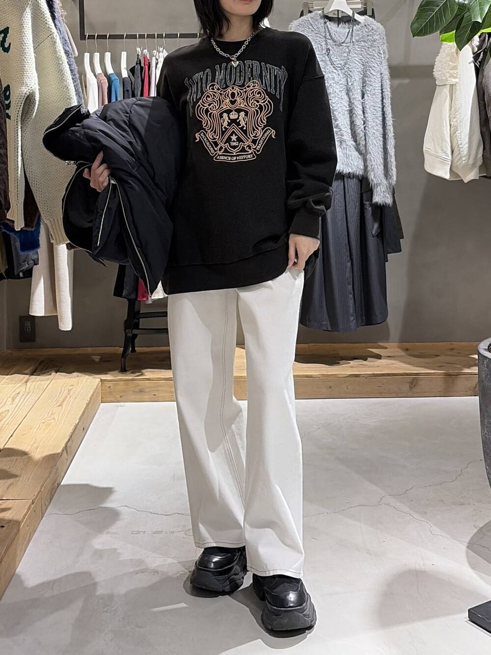 ブラック系のブーツ、ブラック系のブルゾン、ホワイト系のスラックスを着用したレディースの冬コーディネートの6枚目の写真