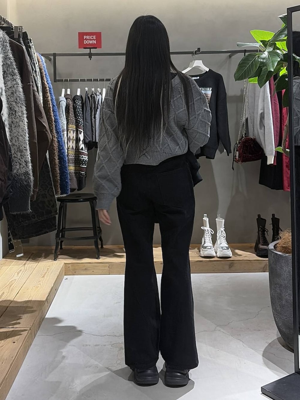 ブラック系のブーツ、ブラック系のデニムパンツ、ブラック系のブルゾンを着用したレディースの冬コーディネートの3枚目の写真