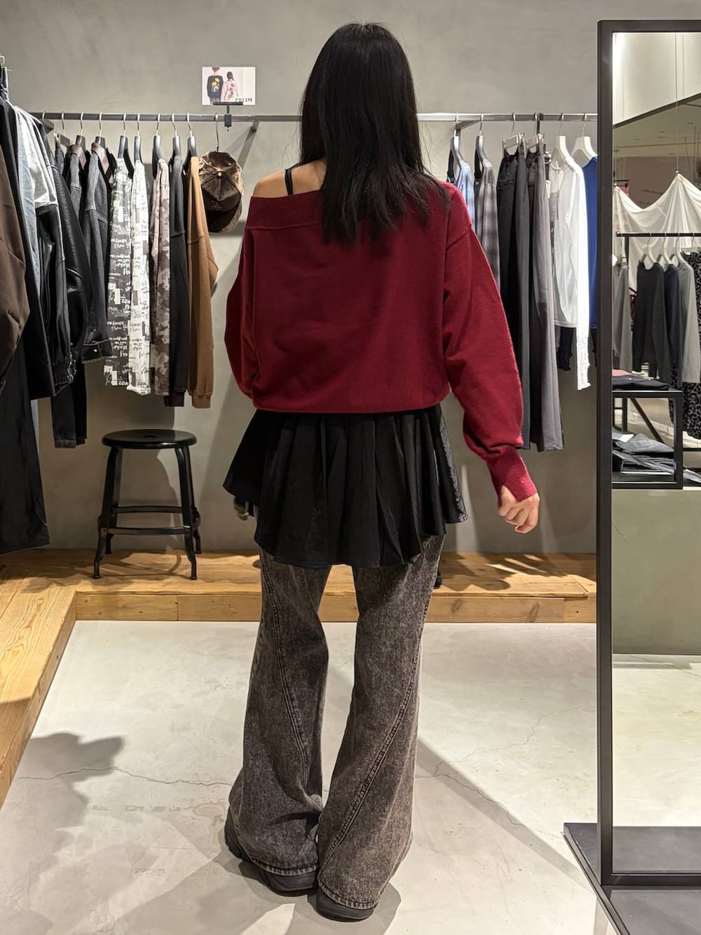 レッド系のニット/セーター、ブラック系のワンピース、ブラック系のブーツを着用したレディースの秋コーディネートの3枚目の写真