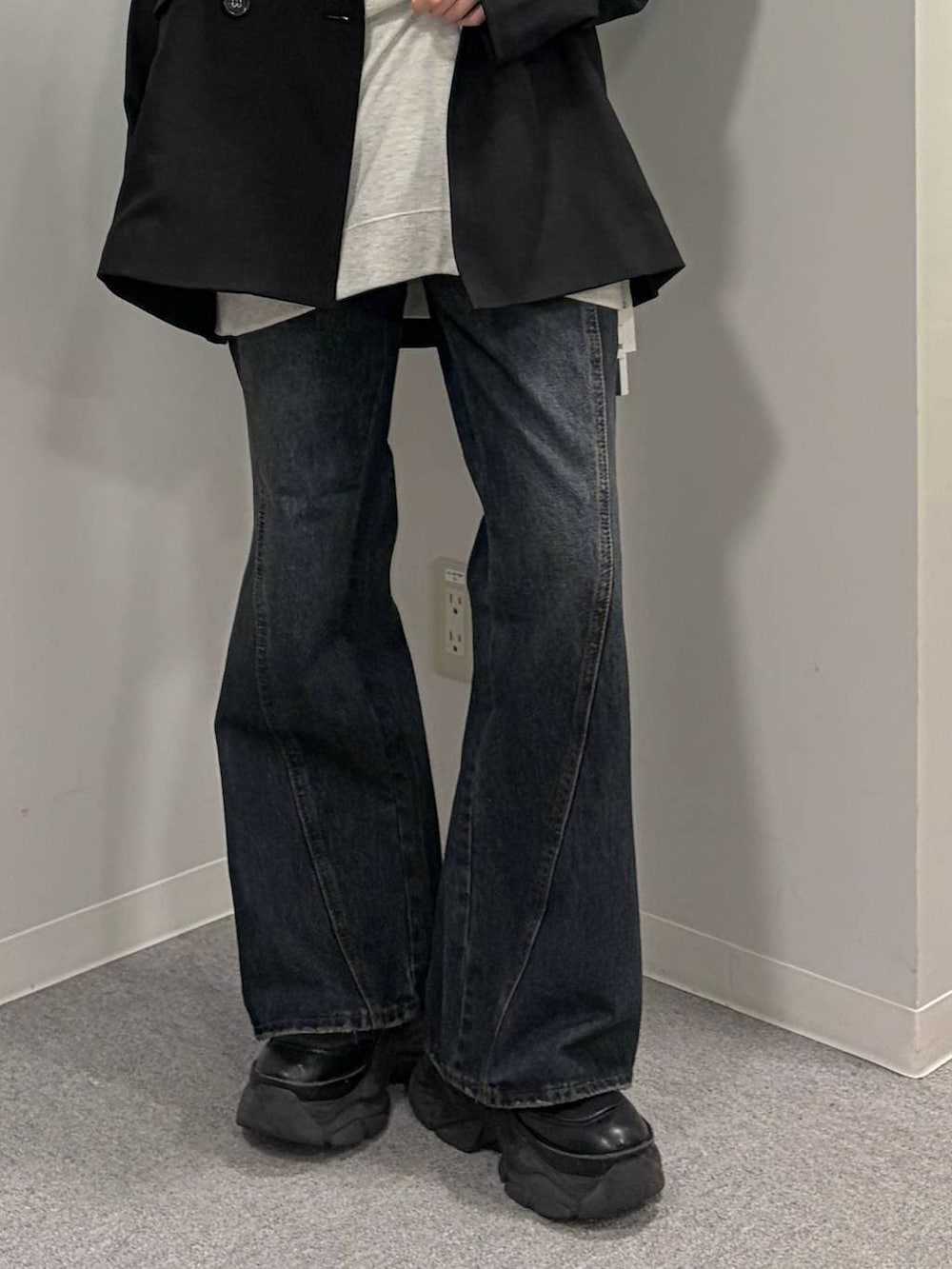 ブラック系のブーツ、ブルー系のデニムパンツ、ベージュ系のTシャツ/カットソーを着用したレディースの春コーディネートの5枚目の写真