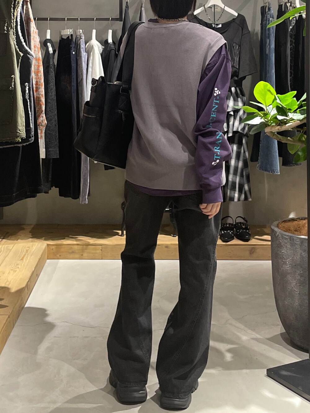 グレー系のベスト、パープル系のTシャツ/カットソー、ブラック系のボストンバッグを着用したレディースの秋コーディネートの3枚目の写真