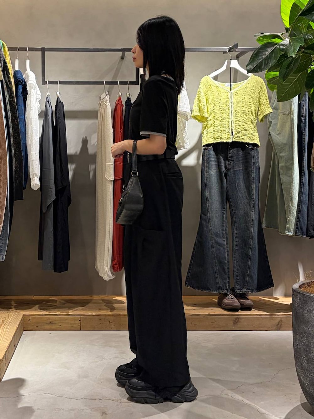 ブラック系のハンドバッグ、ブラック系のその他パンツ、ブラック系のTシャツ/カットソーを着用したレディースの春コーディネートの2枚目の写真
