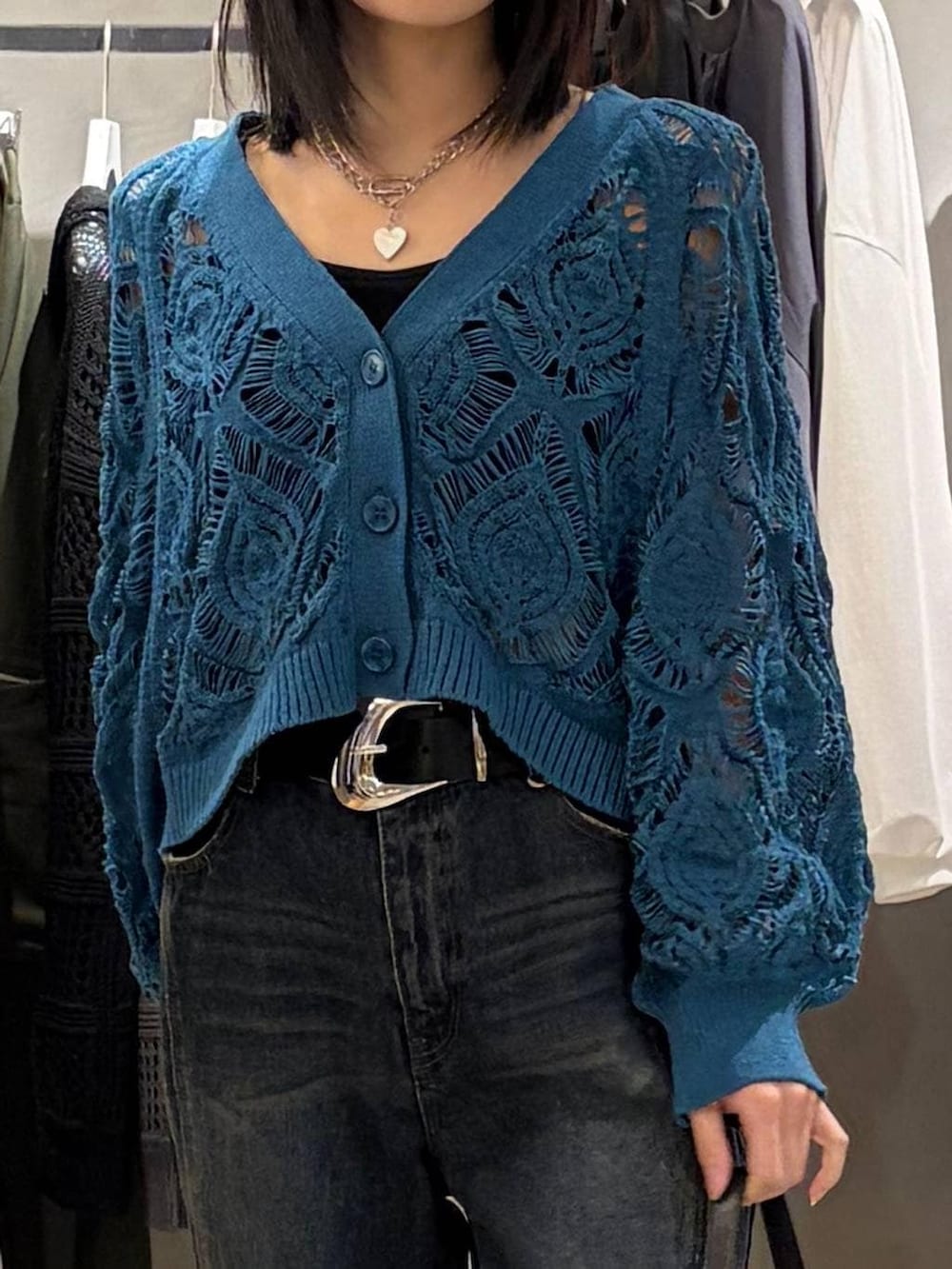 ブルー系のカーディガン/ボレロ、ブルー系のデニムパンツ、ブラック系のハンドバッグを着用したレディースの春コーディネートの4枚目の写真