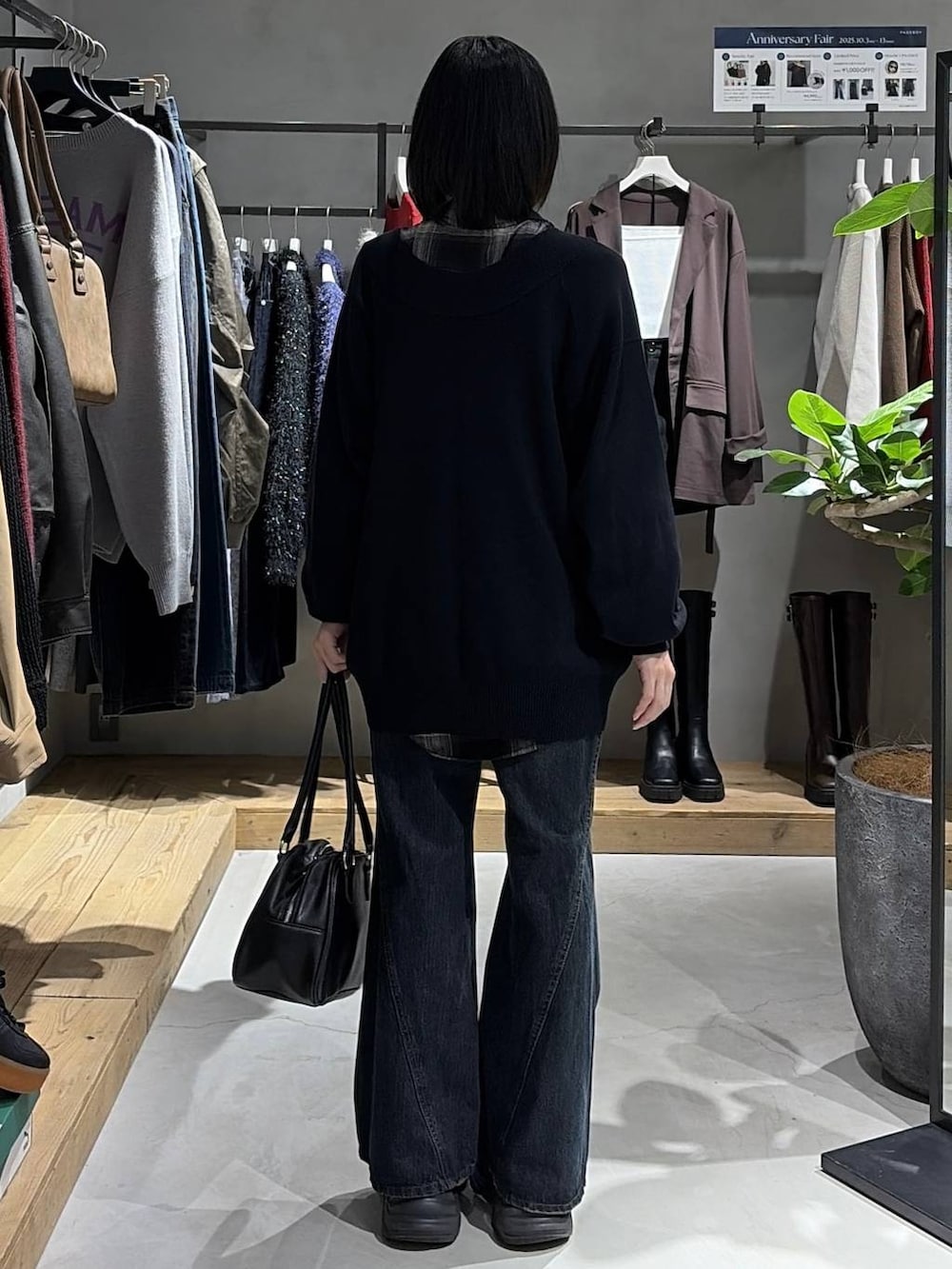 ブラック系のブーツ、ブルー系のデニムパンツ、ブラック系のシャツ/ブラウスを着用したレディースの秋コーディネートの3枚目の写真