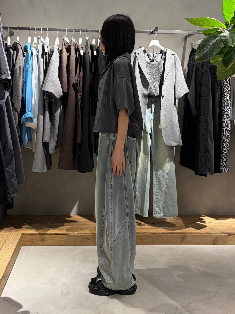ブルー系のデニムパンツ、ブラック系のサンダル、ブラック系のタンクトップを着用したレディースの夏コーディネートの2枚目の写真