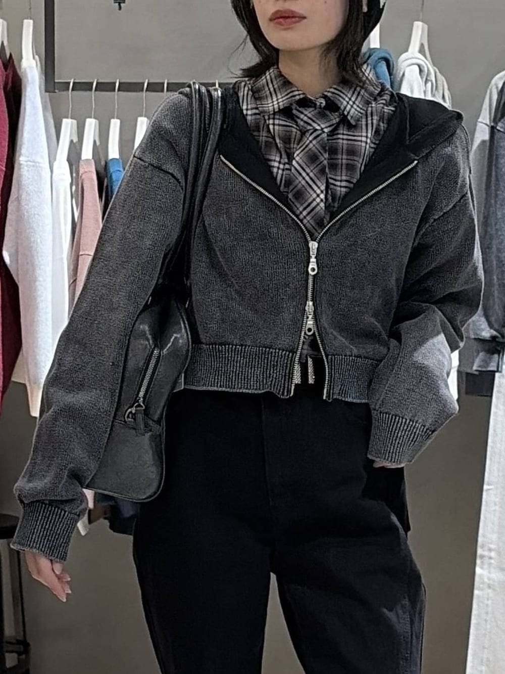 ブラック系のブーツ、ブラック系のボストンバッグ、ブラック系のデニムパンツを着用したレディースの冬コーディネートの4枚目の写真