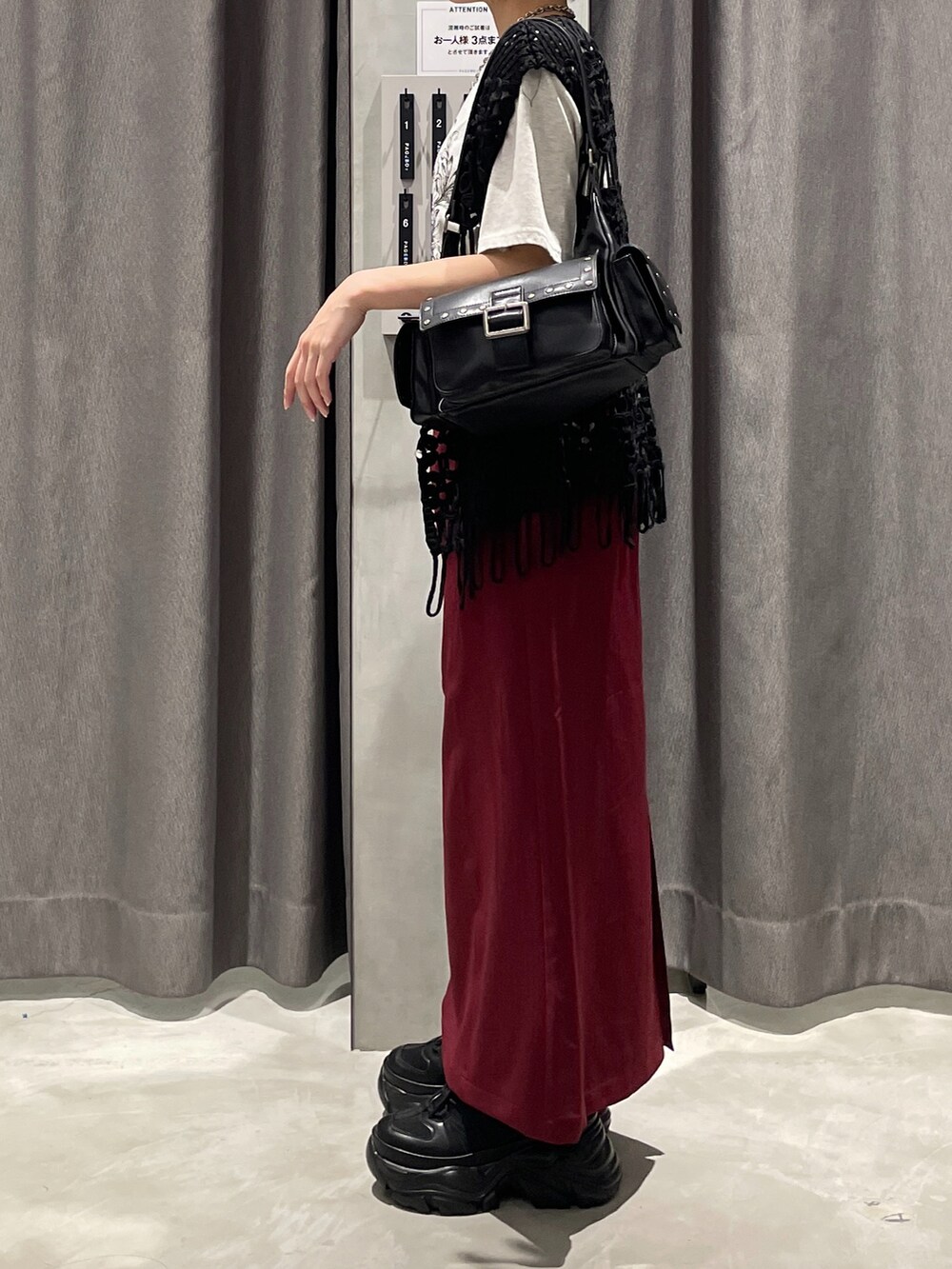 ブラック系のベスト、ベージュ系のTシャツ/カットソー、レッド系のスカートを着用したレディースの夏コーディネートの2枚目の写真