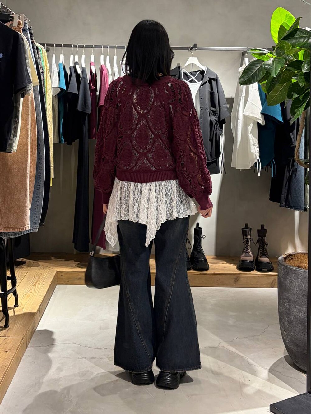 パープル系のカーディガン/ボレロ、ブルー系のデニムパンツ、ブラック系のハンドバッグを着用したレディースの春コーディネートの3枚目の写真