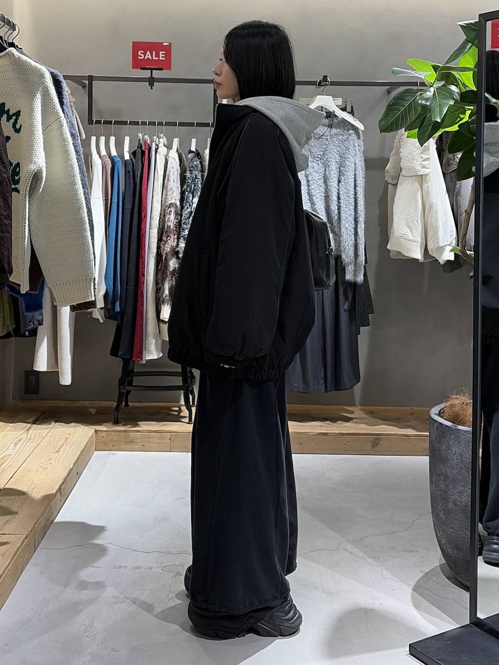 ブラック系のブーツ、ブラック系のニット/セーター、ブラック系のナイロンジャケットを着用したレディースの冬コーディネートの2枚目の写真