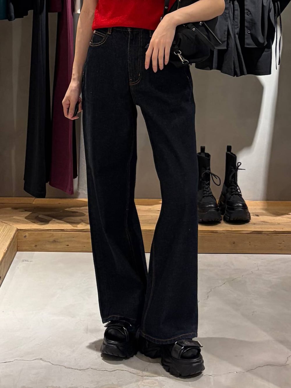 ブルー系のデニムパンツ、ブラック系のサンダル、ブラック系のトートバッグを着用したレディースの春コーディネートの5枚目の写真