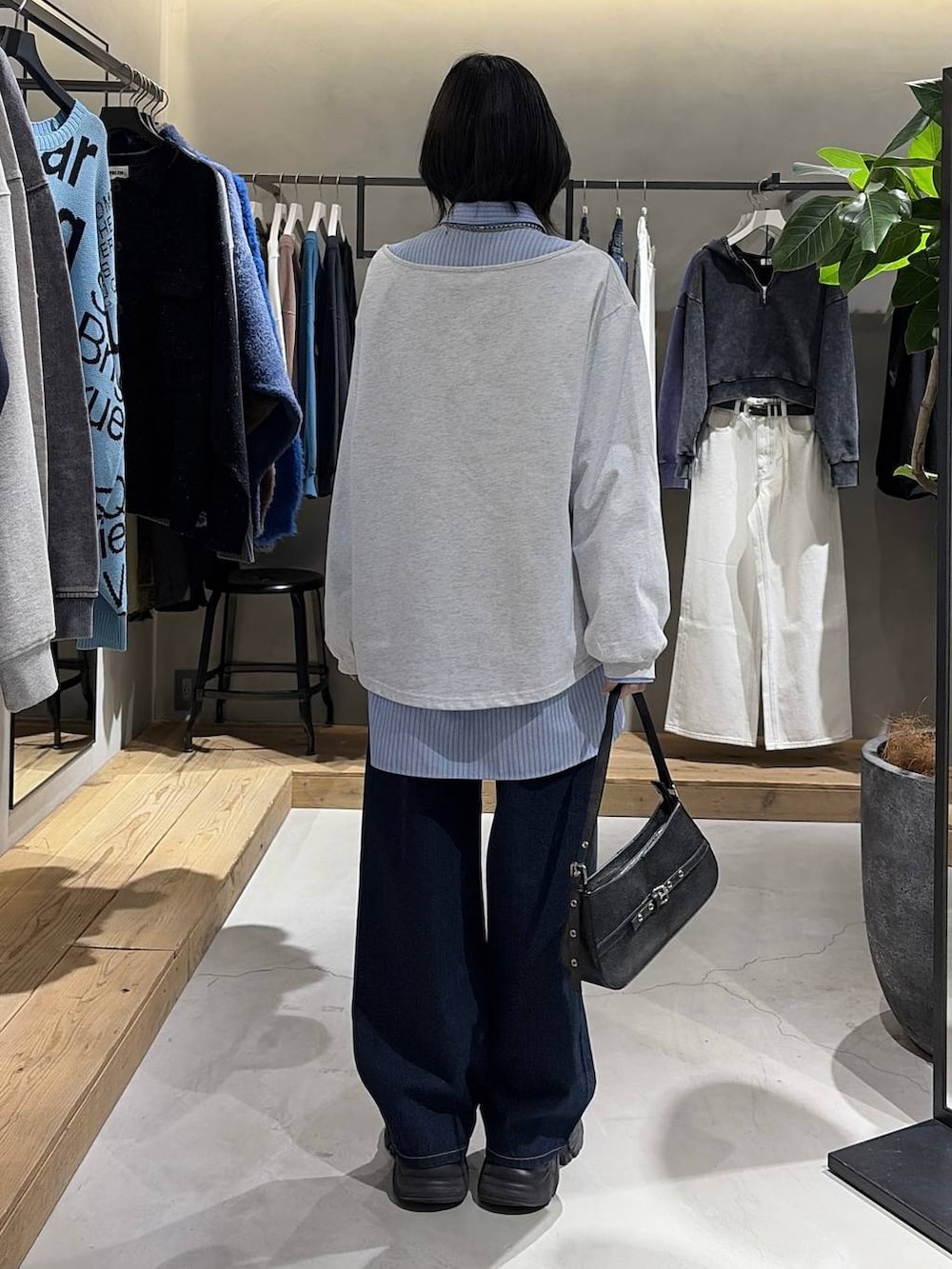 ブラック系のブーツ、ブルー系のスラックス、ブラック系のハンドバッグを着用したレディースの冬コーディネートの3枚目の写真