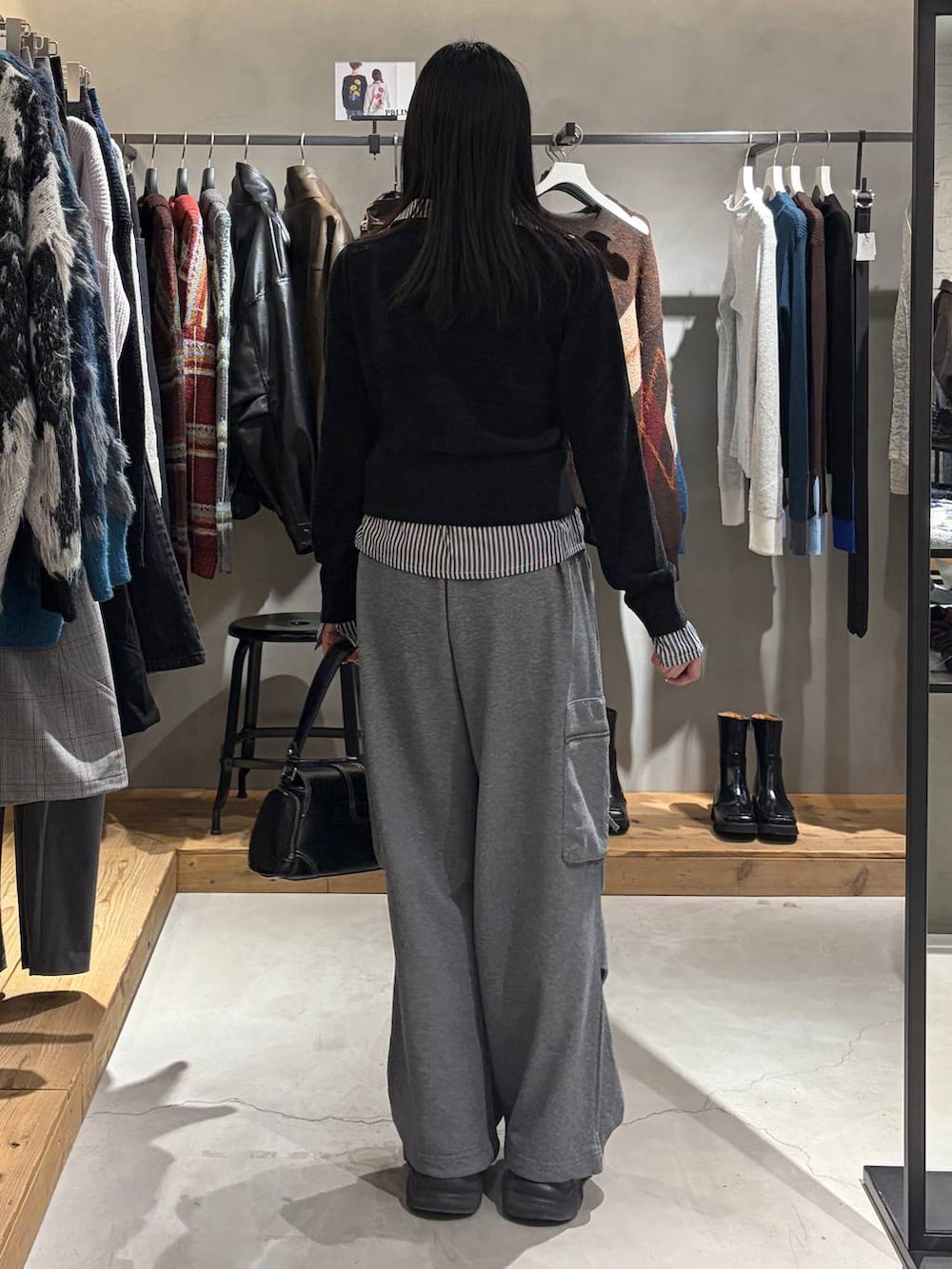 ブラック系のショルダーバッグ、ブラック系のカーディガン/ボレロ、グレー系のスウェットパンツを着用したレディースの秋コーディネートの3枚目の写真