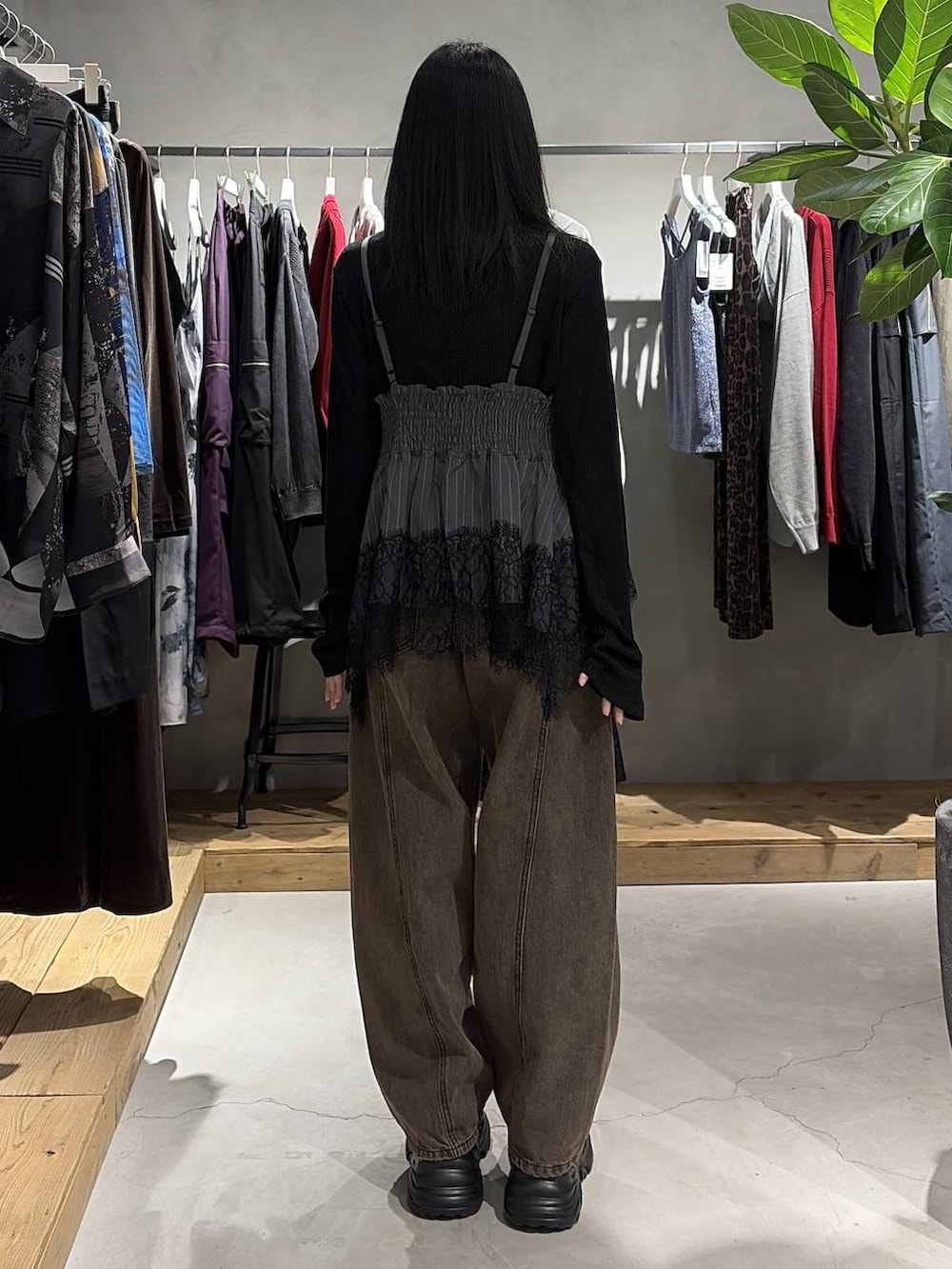 ブラウン系のデニムパンツ、ブラック系のスニーカー、ブラック系のニット/セーターを着用したレディースの夏コーディネートの3枚目の写真