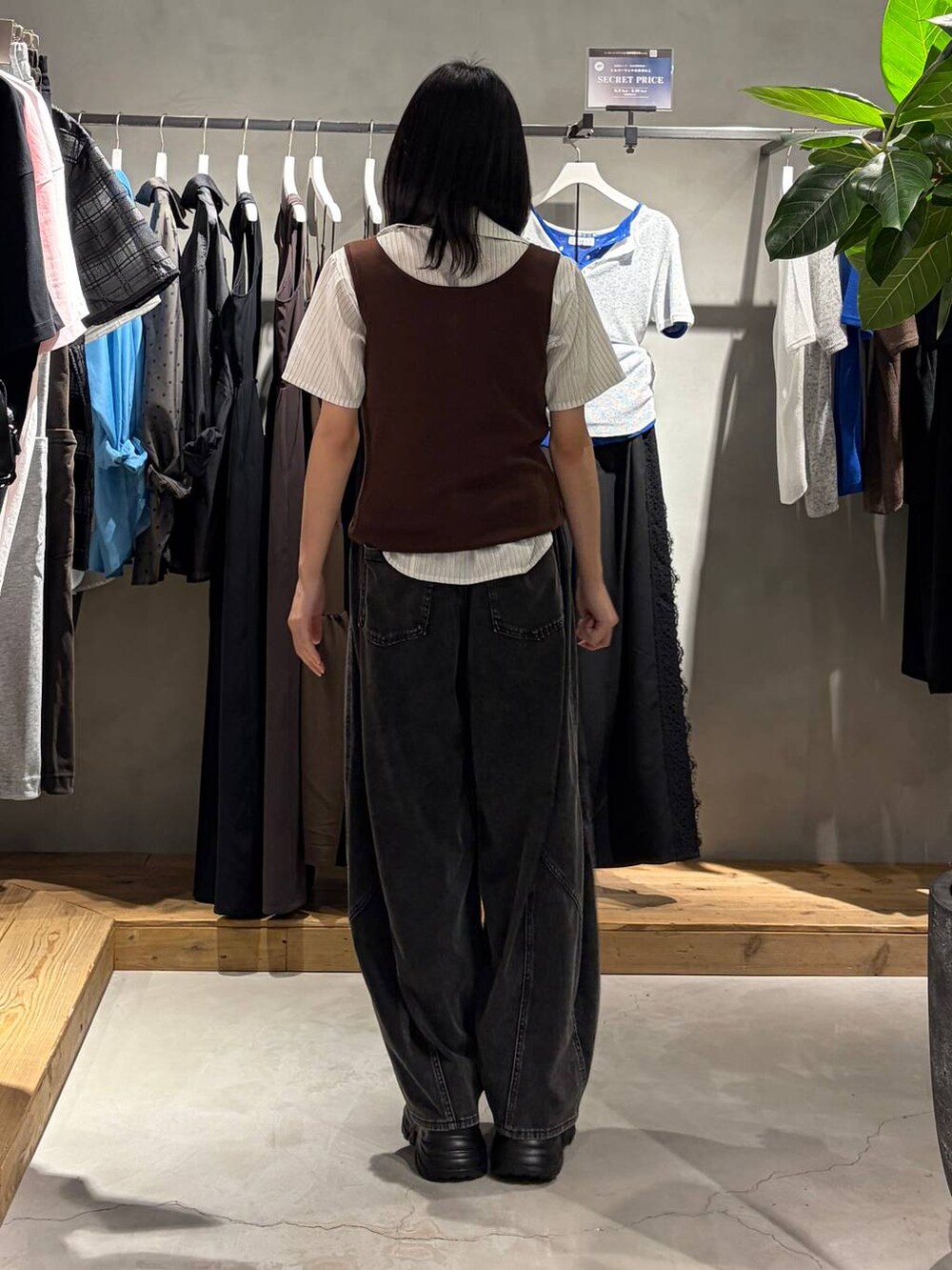 ブラック系のスニーカー、ブラック系のデニムパンツ、ブラウン系のタンクトップを着用したレディースの夏コーディネートの3枚目の写真