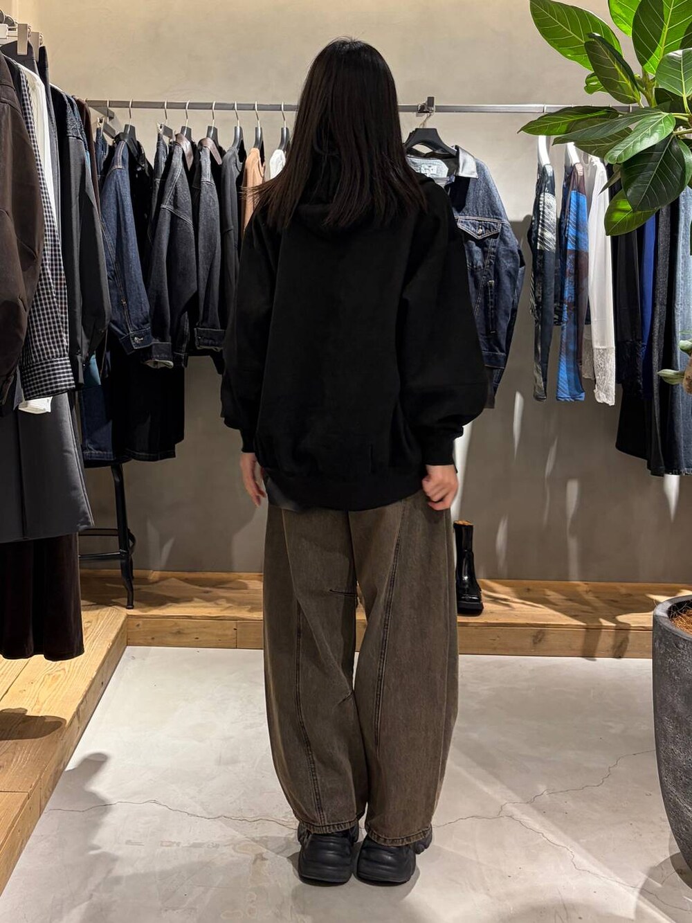 ブラック系のパーカー、ブラック系のシャツ/ブラウス、ブラウン系のデニムパンツを着用したレディースの秋コーディネートの3枚目の写真