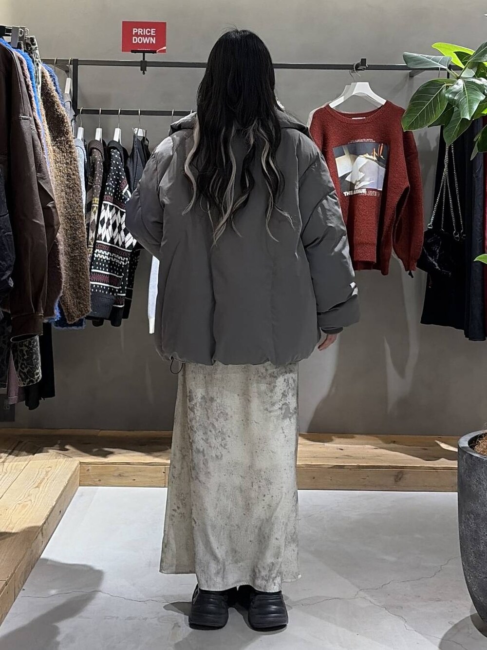 ブラック系のブーツ、グレー系のブルゾン、ホワイト系のスカートを着用したレディースの冬コーディネートの3枚目の写真