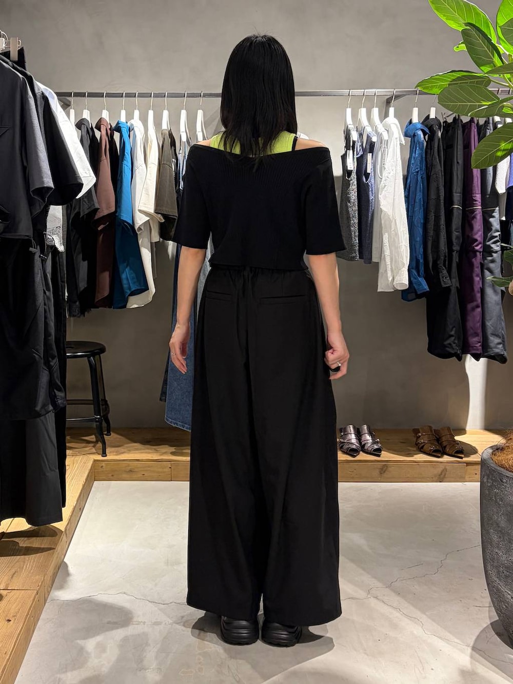ブラック系のスラックス、ブラック系のTシャツ/カットソー、ブラック系のスニーカーを着用したレディースの夏コーディネートの3枚目の写真