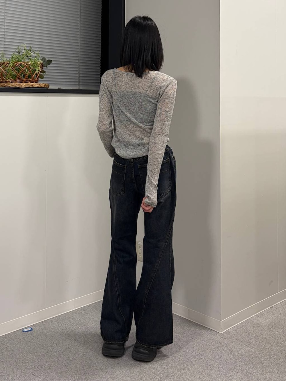 ブラック系のブーツ、ブルー系のデニムパンツ、グレー系のTシャツ/カットソーを着用したレディースの春コーディネートの3枚目の写真