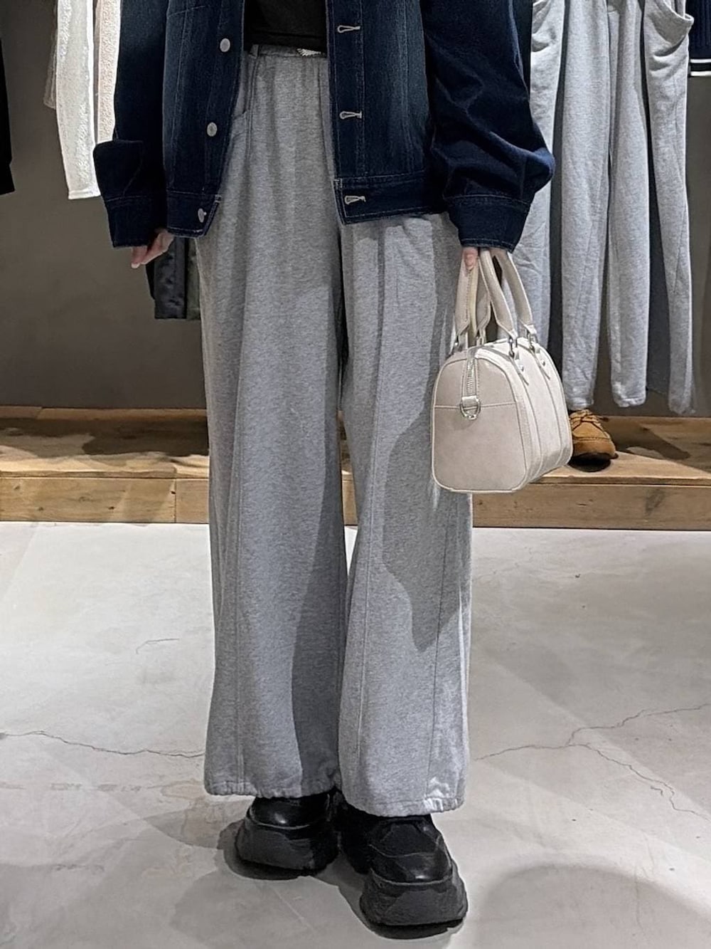 ブラック系のブーツ、ホワイト系のボストンバッグ、グレー系のスウェットを着用したレディースの冬コーディネートの5枚目の写真