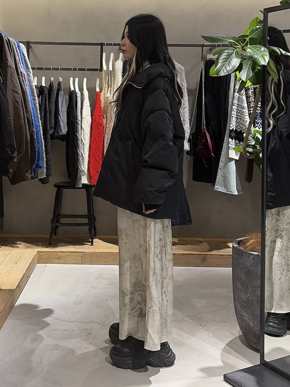 ブラック系のブーツ、ブラック系のブルゾン、ホワイト系のニット/セーターを着用したレディースの冬コーディネートの2枚目の写真